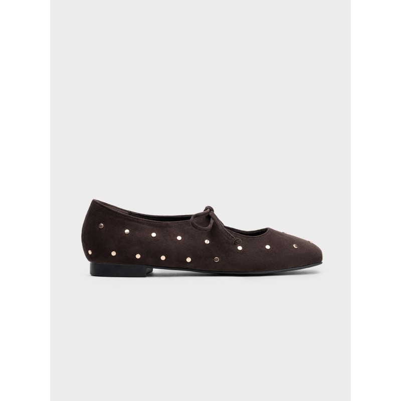 Zapato plano estilo bailarina con lazos y remaches metálicos, diseño elegante, comodidad para uso diario.