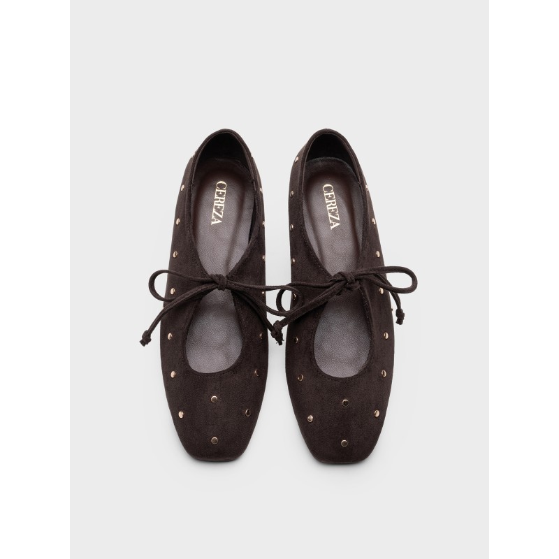 Zapato plano estilo bailarina con lazos y remaches metálicos, diseño elegante, comodidad para uso diario.