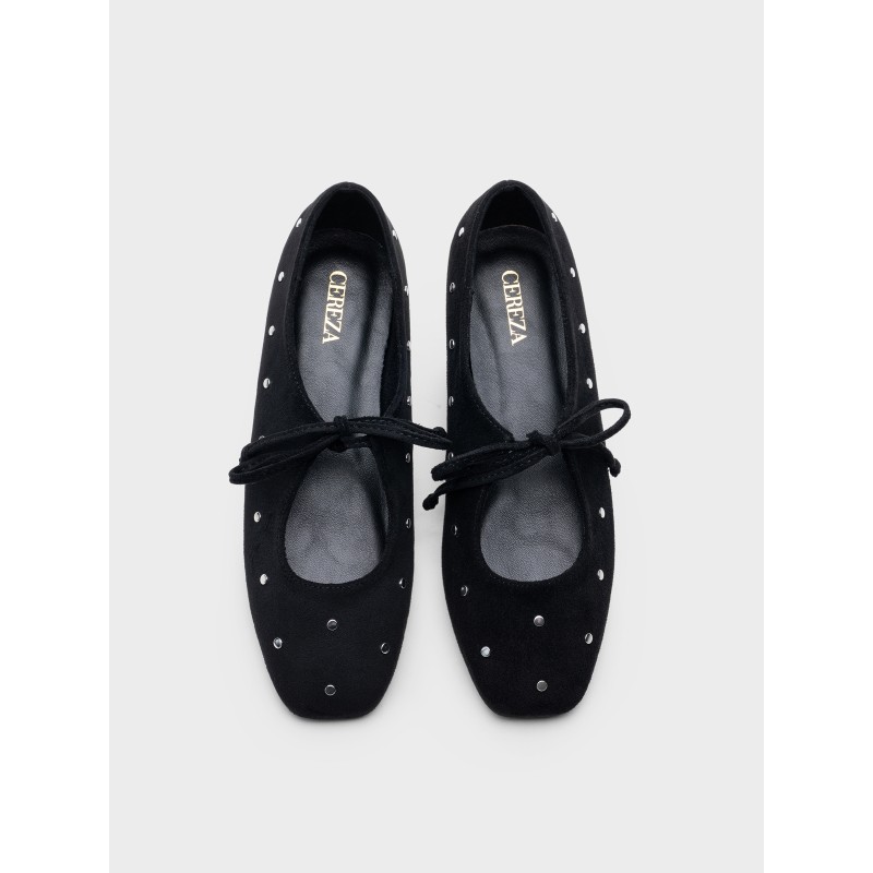 Zapato plano estilo bailarina con lazos y remaches metálicos, diseño elegante, comodidad para uso diario.